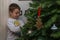 Eight Years Boy Hanging Balls and Decorations on Christmas Tree