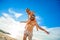 Eight years old boy sitting on dad`s shoulders. Both in swimming shorts and sunglasses, having fun on the beach. Bottom view