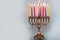 Eighth day of Hanukkah with burning Hanukkah colorful candles in Menorah.
