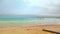 Ein Bokek, Israel - January 22, 2020: Calm day at Ein Bokek Dead Sea beach, blue green water, sun shade shelter near, sun shines