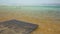 Ein Bokek, Israel - January 22, 2020: Calm day at Ein Bokek Dead Sea beach, blue green water, sun shade shelter near, sun shines