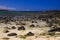 El Cotillo, North Fuerteventura: View over bright scattered stoneson beach in shallow water on turquoise lagoon of beach La Concha