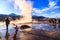 El Tatio Geyser site, San Pedro de Atacama with tourists visiting. Photographer at El Tatio geysers, Chile at sunrise