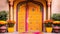 An elaborate door decorated with vibrant rangoli patterns and marigold flowers to greet guests on Diwali.