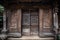 A elaborately carved wooden door of a traditional stilt house. Portray the historic architecture and cultural heritage of