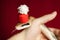 Elaphe taeniura snake in red christmas hat on red on the hand