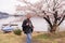 Elder asian man with camera on his neck with sakura in Japan