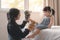 Elder asian sister and younger Asian sister playing animal hand puppet doll toys, sitting on bed, Educational preschool games,