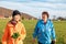 Elder caucasian grandmother walking down the park with her granddaughter. Family outdoor vacation. Side view