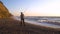 Elder Fisherman in Hat fishing at sunrise on the Coast of the Sea at Windy Weather