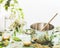 Elder flower syrup or jam preparation. Pot with spoon , Elderflowers and lemon on kitchen table