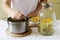 Elder flowers, water, lemon and sugar, ingredients and a woman preparing an elderberry syrup. Rustic style.