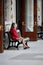 Elder lonely lady at her sixties sits on the bench of a station and waits for someone