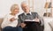 Elder man showing illustration in book to wife