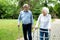 Elder people using walking cane and a walker for a gentle stroll in the park