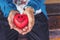 Elder senior women holding read heart with smiling. Close up women hands with red heart, care and healthy concept.