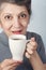 An elder smiling woman holding cup of tea