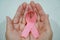 Elder woman hands holding pink breast cancer awareness ribbon. Medicine and healthcare concept. Mother and World cancer day