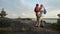 Elderly active couple climbing on the rock and admiring the sunrise, the sunset.