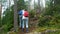 Elderly active couple climbing on the rock in the northern forest.