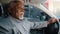Elderly african american businessman driving automobile on roadway experienced confident driver carefully looks at road