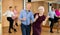 Elderly amateur couple practicing vigorous lindy hop in studio