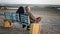 Elderly Arabian couple sit on a bench and look at the sea
