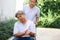 An elderly asia ; midle - aged man patient sit on a wheelchair ,his wife take care for him