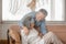 Elderly asian carrying his wife in pain lying on sofa in living room at home, family health care and support concept