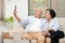 An elderly Asian couple watches online media on their Smart phone in the living room