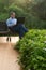 An elderly Asian man working on a laptop sitting in a chair outside the house in the morning. remote working concept high quality.