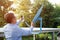 An elderly Asian satellite technician is adjusting the satellite dish to a suitable signal to receive television signals at home.