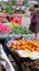 Elderly Asian woman chooses fruit in the bazaar