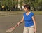 An elderly athlete trains with a racket and a tennis ball.