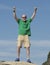 Elderly bald man standing with clenched fists extended overhead