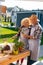 Elderly beaming couple hugging while taking care of flowers and plants