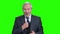 Elderly bearded businessman talking on green screen.