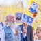 : An elderly bearded man with a portrait of a participant in the Great Patriotic War is walking along the column `Immortal Regime