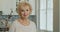 Elderly, beautiful woman smiling looking at the camera. Portrait of senior adult retired lady grandma on the kitchen