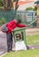 Elderly black man digs in rubbish bin