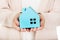 Elderly business woman holding blue paper house