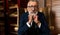 Elderly businessman in formal suit with whiskey and cigar at luxury interior