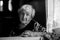 Elderly calm woman in the kitchen of his house sitting at the table