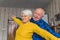 Elderly caucasian couple - grandmother and grandfather - dancing vividly in their old-fashioned apartment. Happy