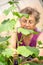 Elderly caucasian woman gardener in greenhouse