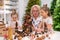 Elderly caucasian woman making pine cones decoration for christmas with two granddaughters