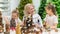 Elderly caucasian woman making pine cones decoration for christmas with two granddaughters