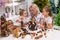 Elderly caucasian woman making pine cones decoration for christmas with two granddaughters