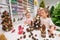 Elderly caucasian woman making pine cones decoration for christmas with two granddaughters