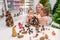 Elderly caucasian woman making pine cones decoration for christmas with two granddaughters